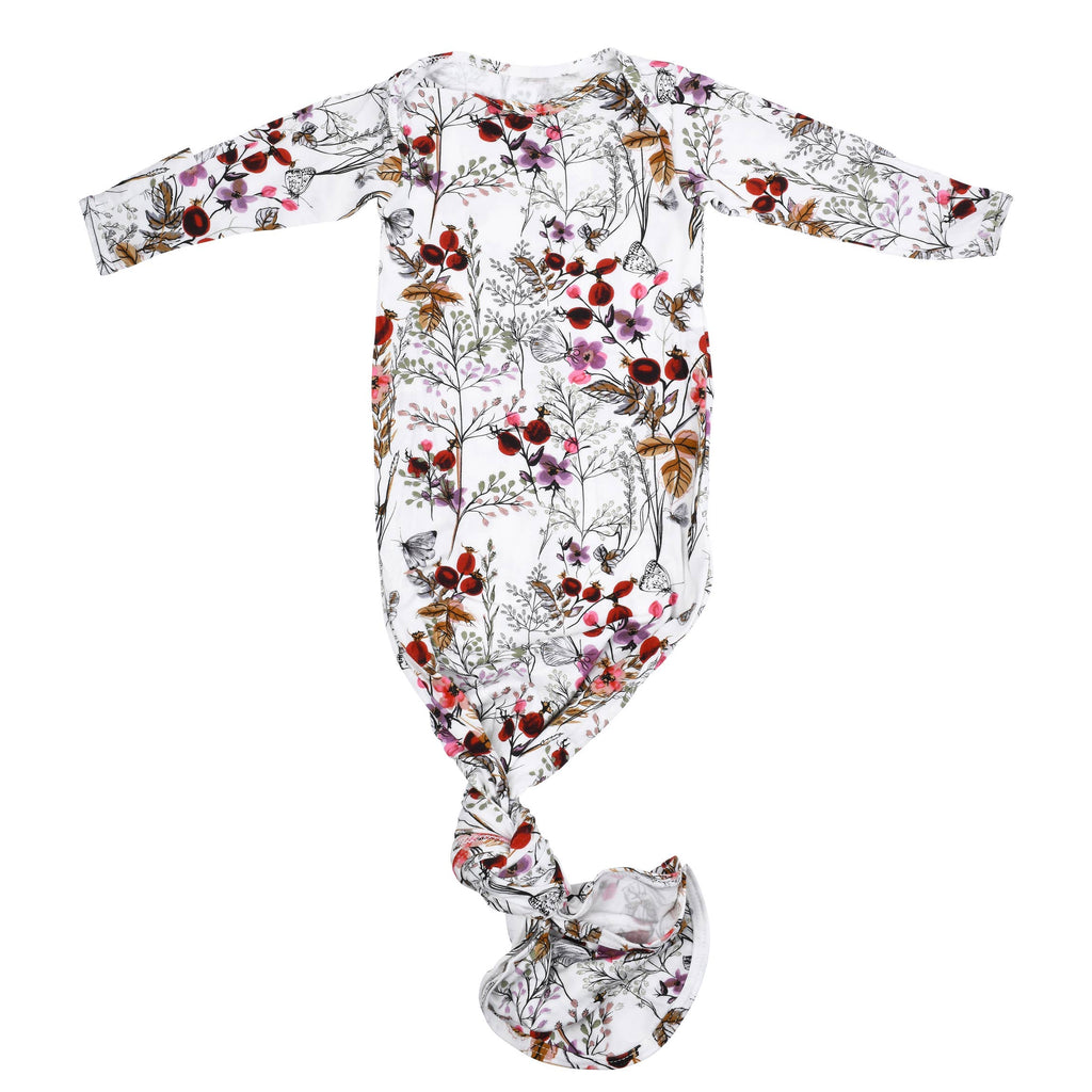 floral gown on a baby laying on a white background