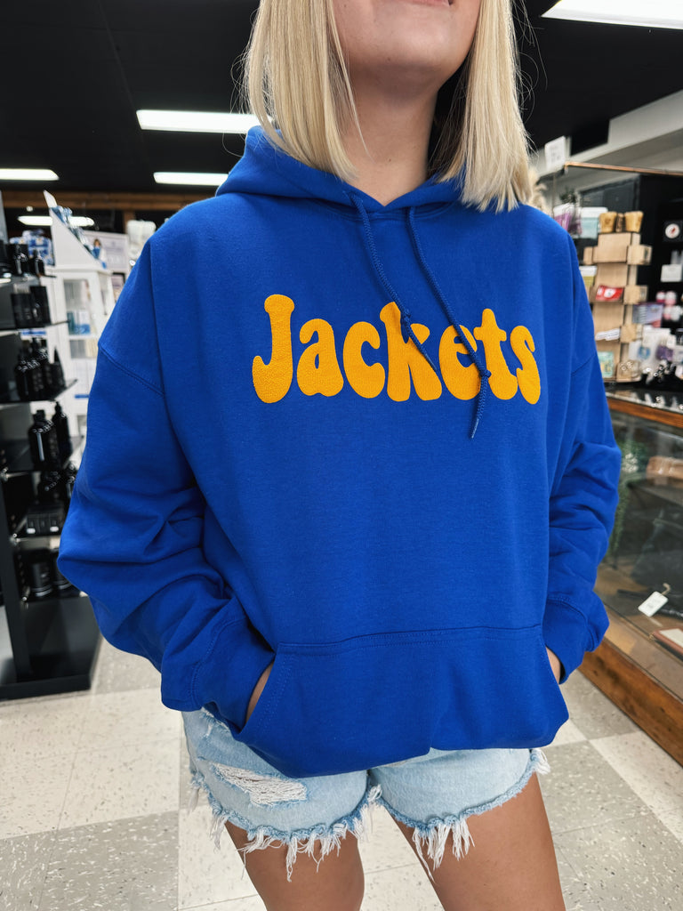 woman wearing a blue hoodie with yellow "jackets" written on in in a retail store setting