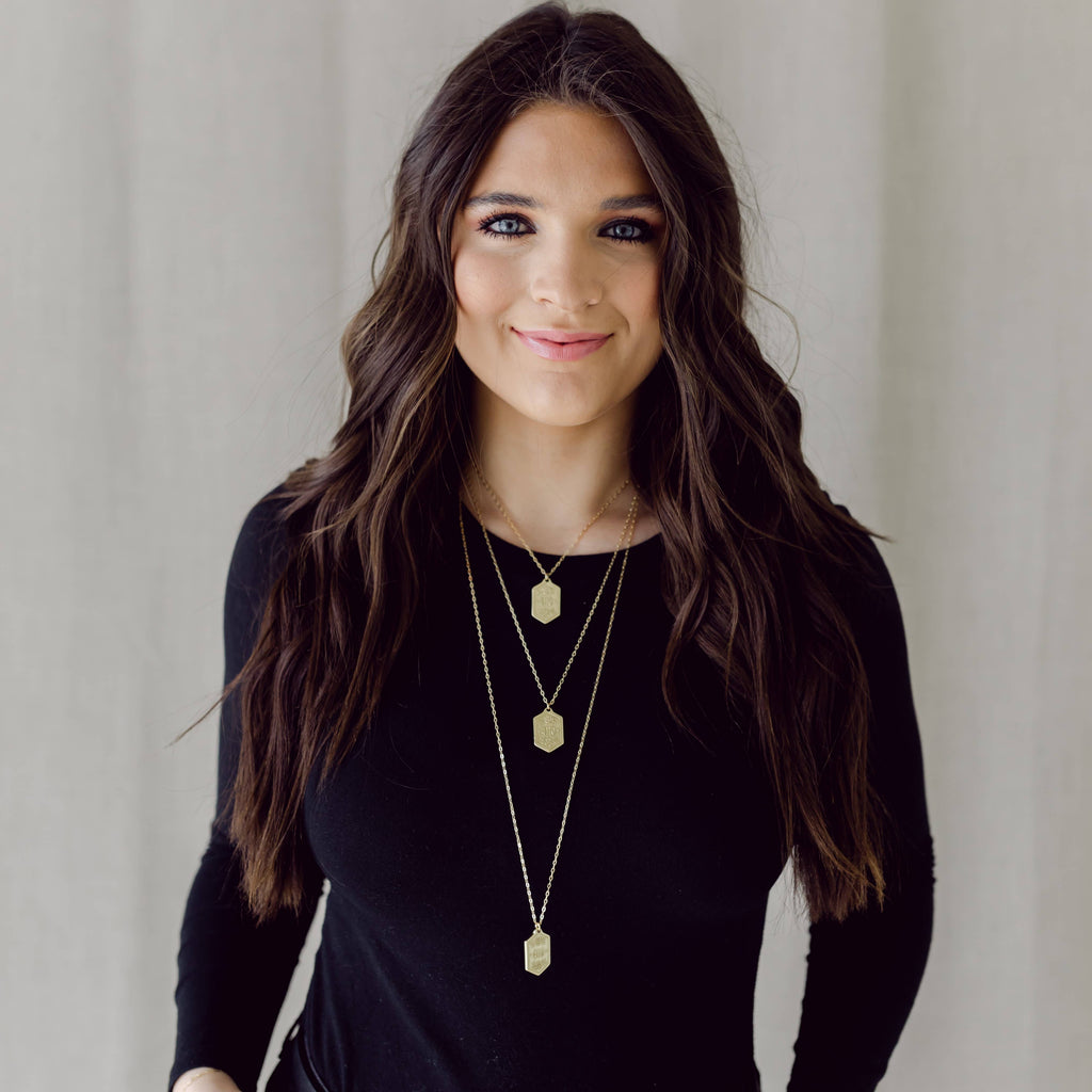 person wearing multiple necklaces on a white background