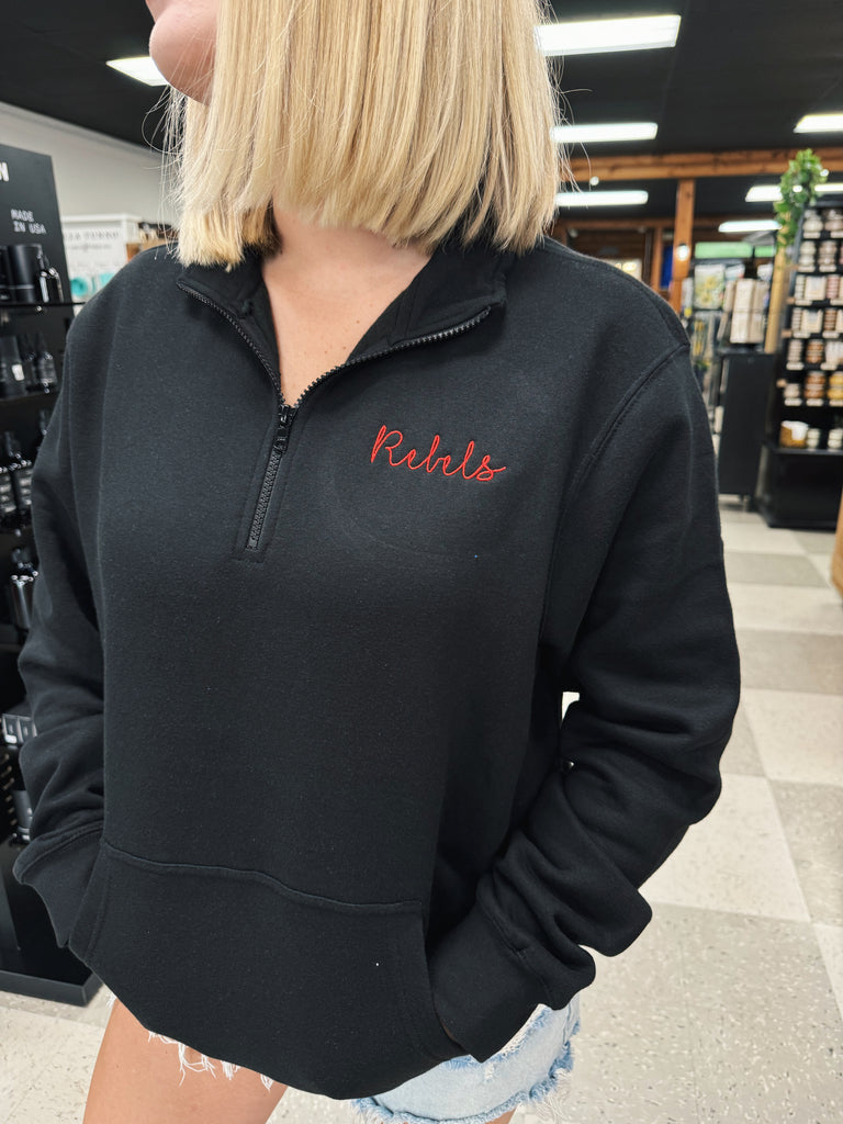 Person wearing a black pullover with red text in a store setting