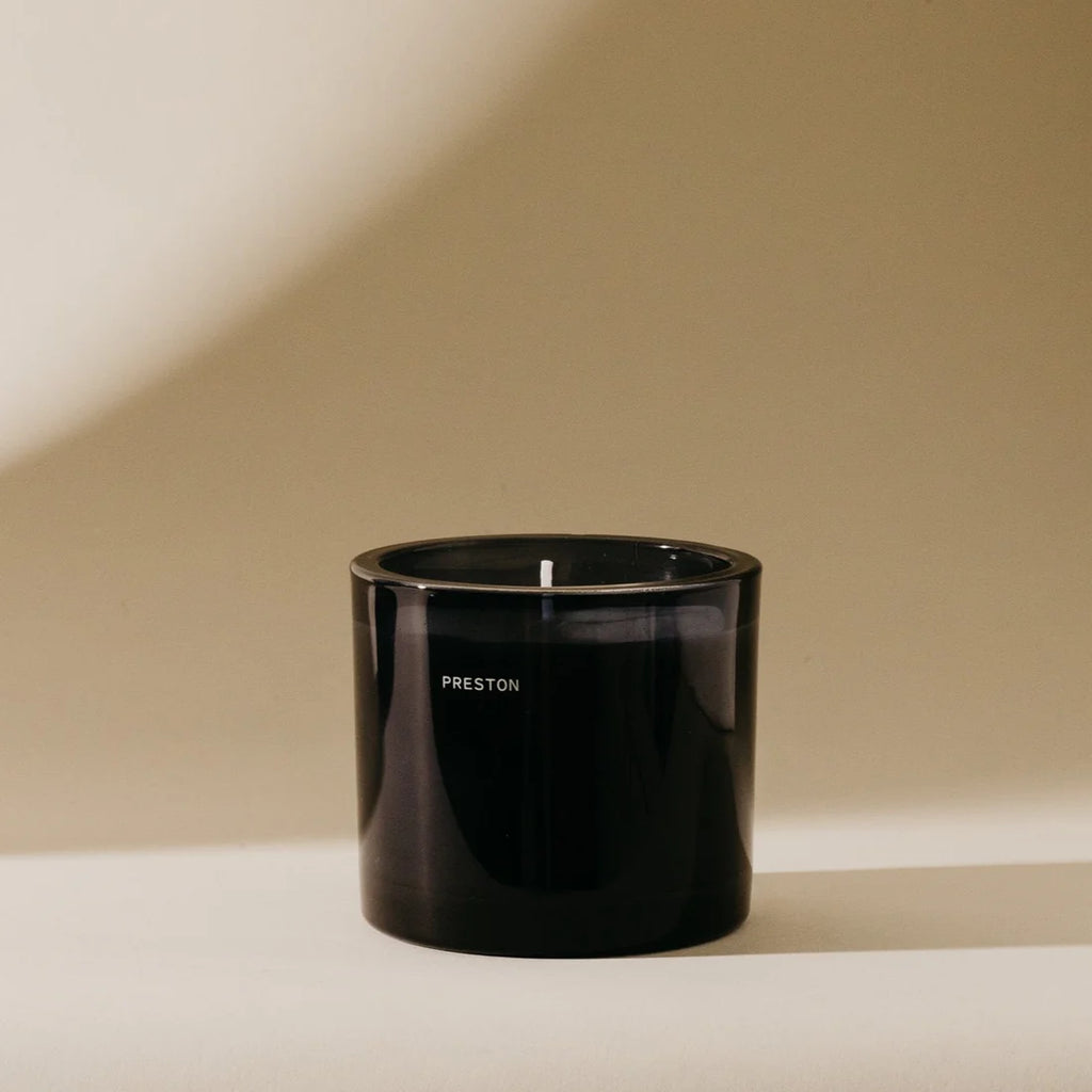 Black candle holder with 'PRESTON' branding on a beige background