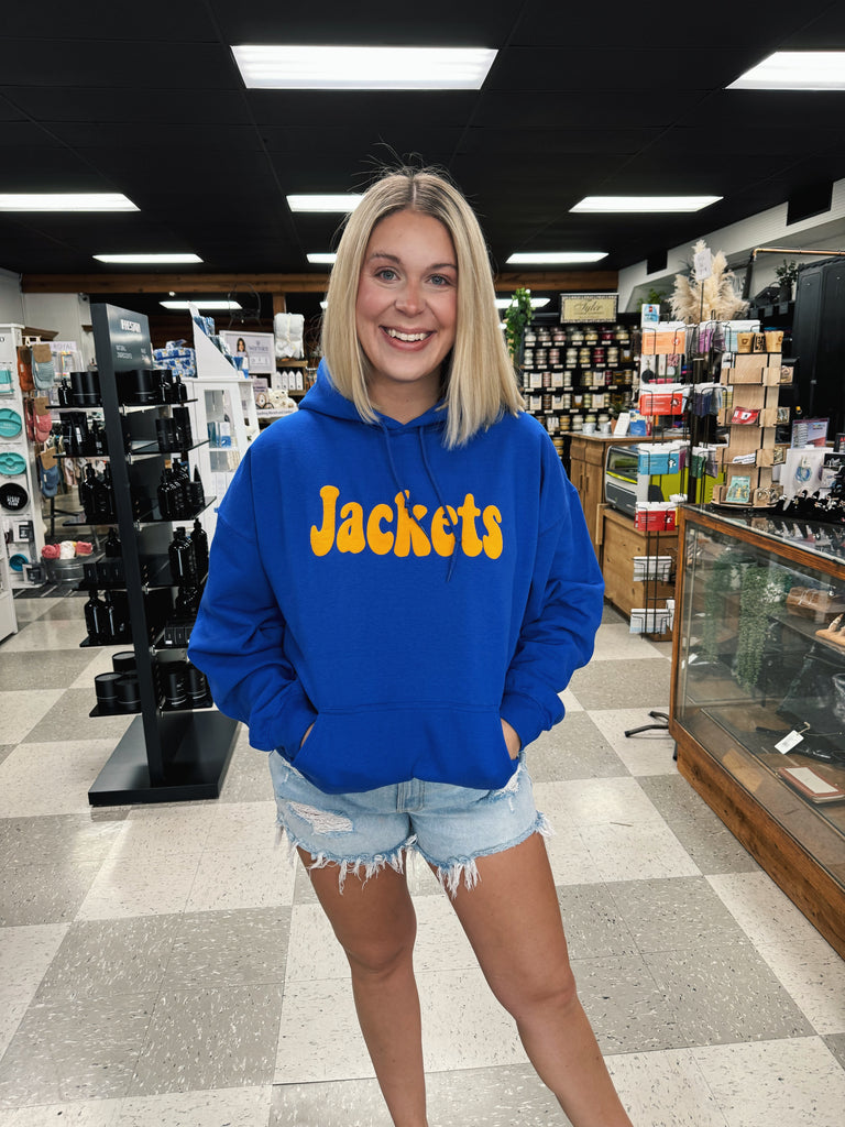 woman wearing a blue hoodie with yellow "jackets" written on in in a retail store setting