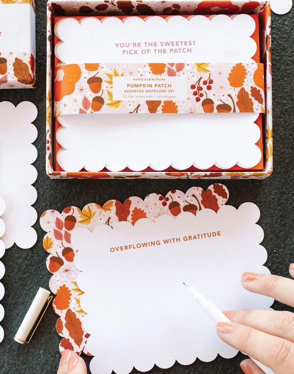 Pumpkin patch-themed stationery set with cards and a box on a dark surface.