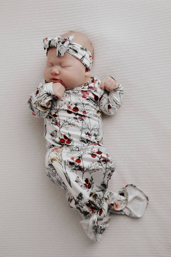 floral gown on a baby laying on a white background