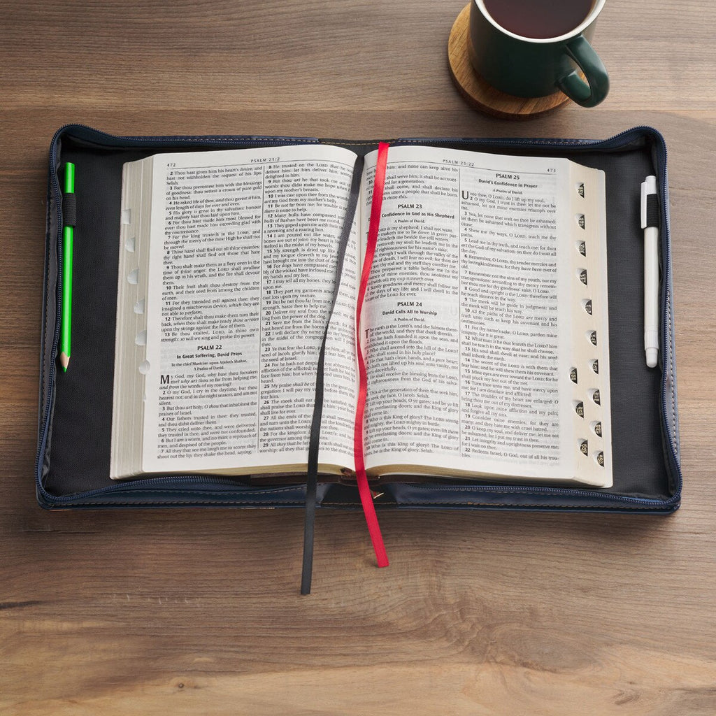 Open book with a pen and pencil on a wooden surface