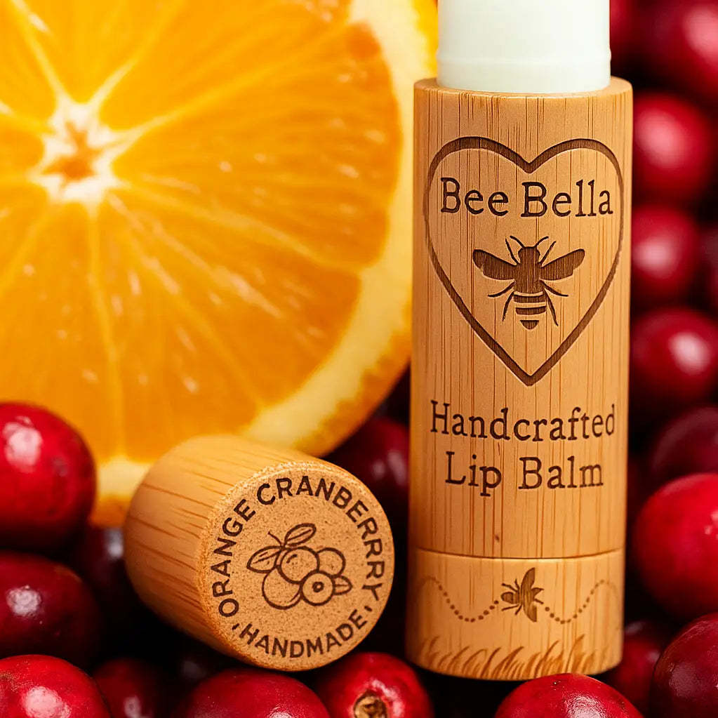 Bee Bella lip balm with bamboo container on a background of oranges and cranberries