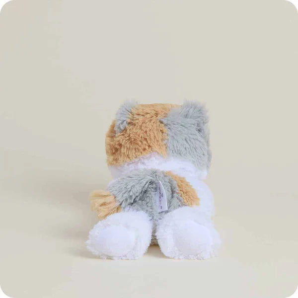 Plush toy resembling a dog with gray, brown, and white fur on a beige background