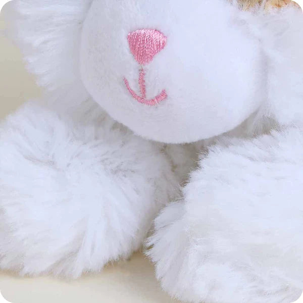 White plush toy with a pink heart on a light background