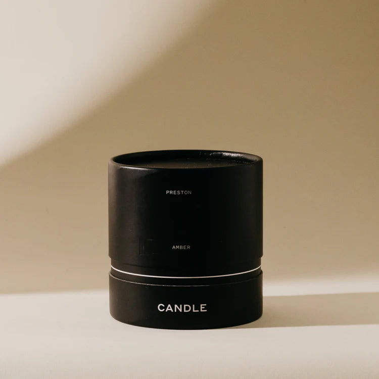 Black candle holder with 'PRESTON' branding on a beige background