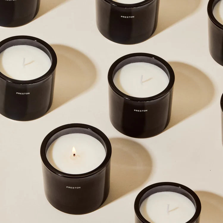Black candle holders with white candles on a light surface