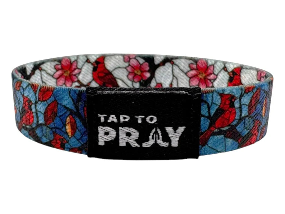 Wristband with floral design and 'Tap to Pray' text on a white background