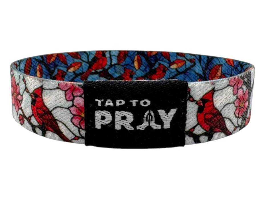 Wristband with floral design and 'Tap to Pray' text on a white background