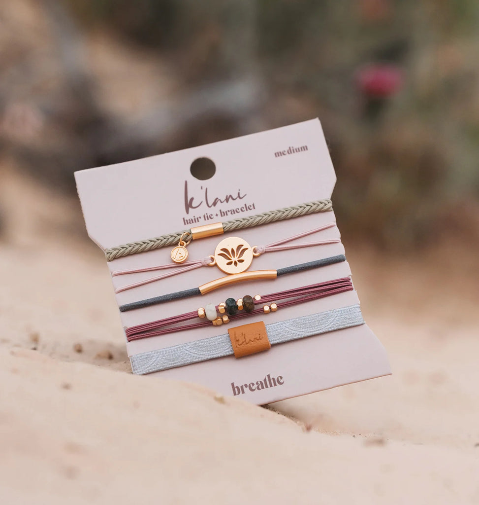 Set of hair ties and bracelets on a 'ke'ani' branded card with a blurred natural background.