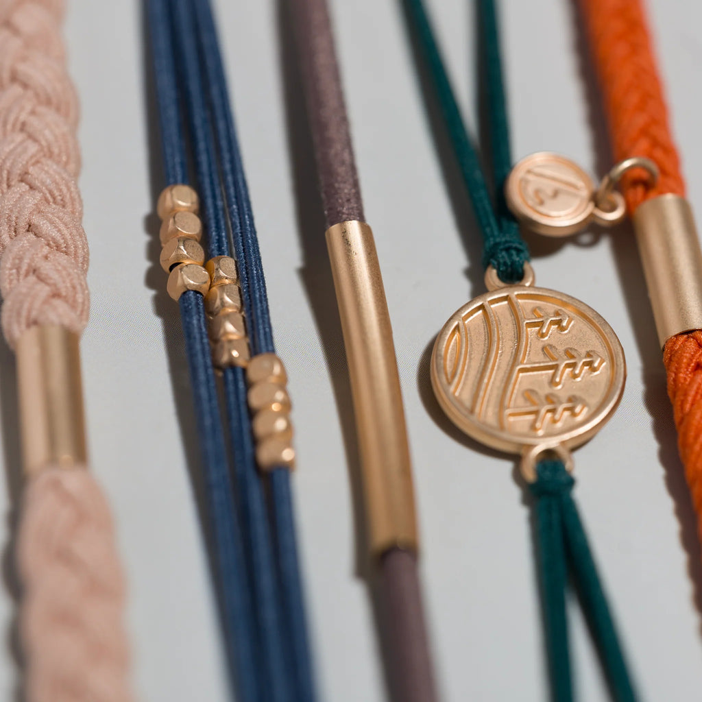 Close-up of colorful bracelets with gold accents on a light background