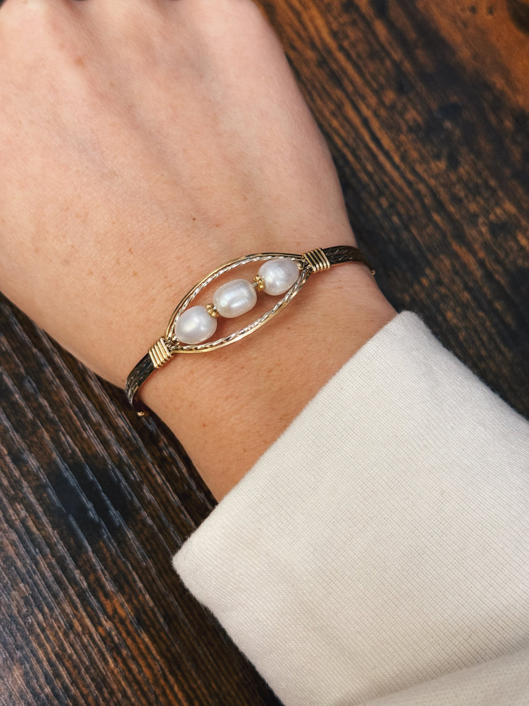 three pearl handmade bracelet with a wooden table in the background