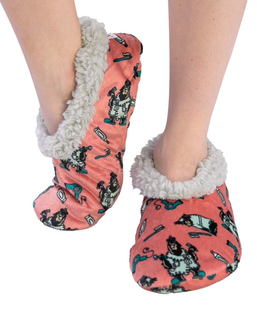 Pink slipper socks with cartoon character pattern and gray fuzzy trim worn by a person on a white background