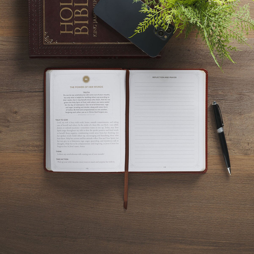 Open notebook on a wooden surface with a pen and plant