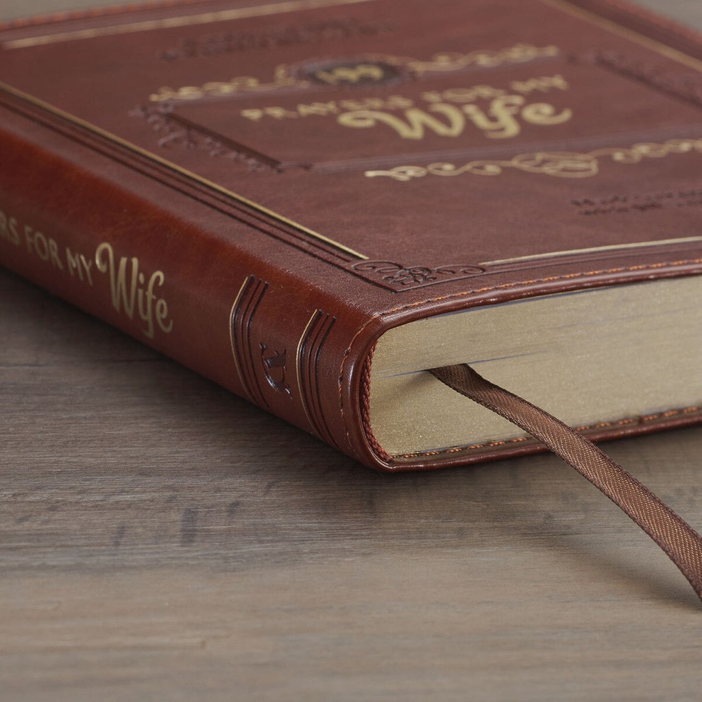 Brown leather book titled 'Prayers for My Wife' on a wooden surface