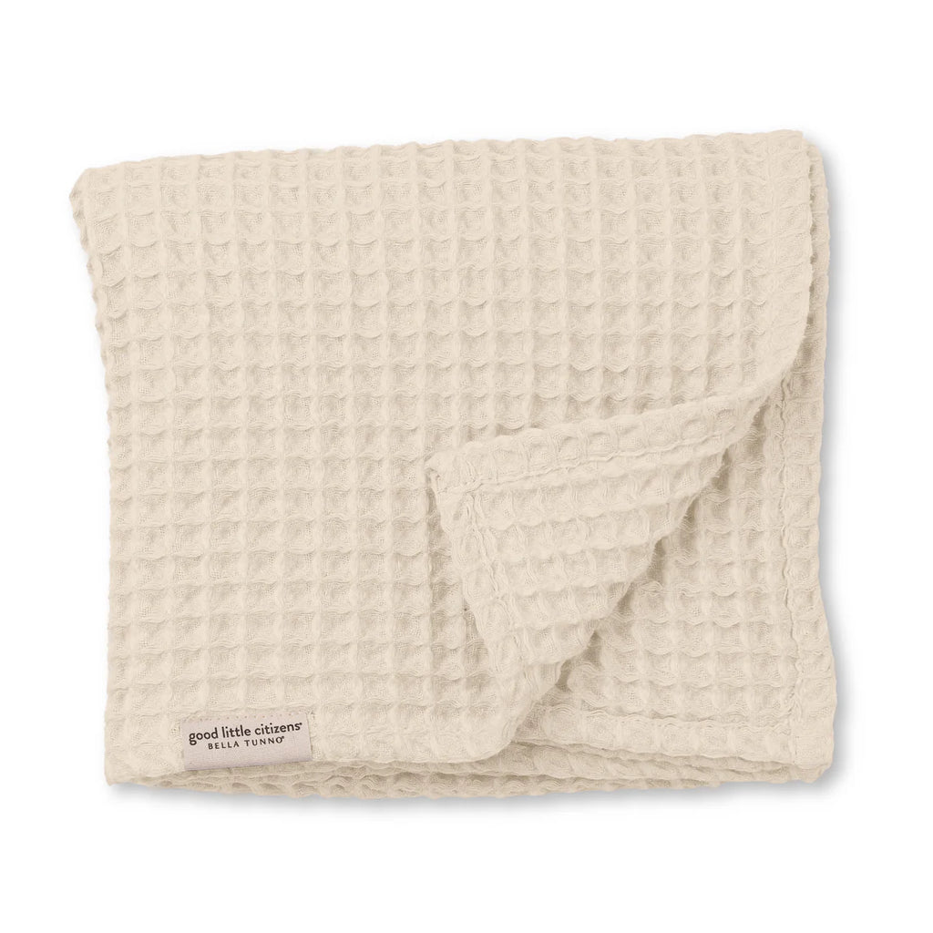 Beige textured blanket with 'good little company' branding on a white background