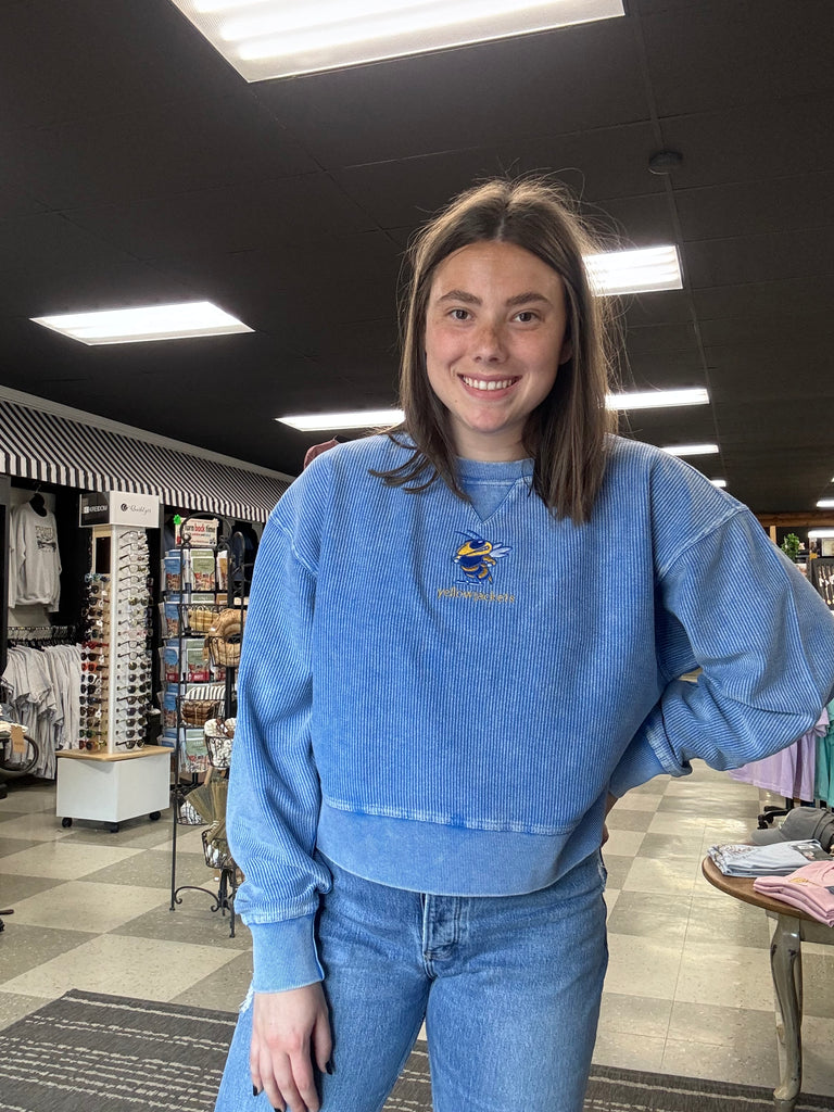 Person wearing a blue jacket with a logo in an indoor setting