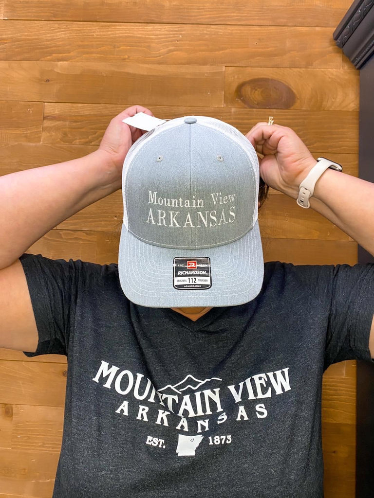 mountain view arkansas hat being worn in front of wood wall