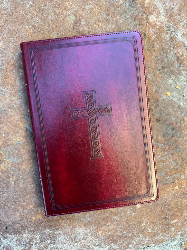 KJV Embossed Cross Burgundy Bible on a brown background