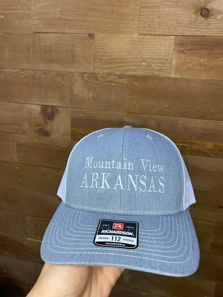 mountain view arkansas hat in front of a wood wall