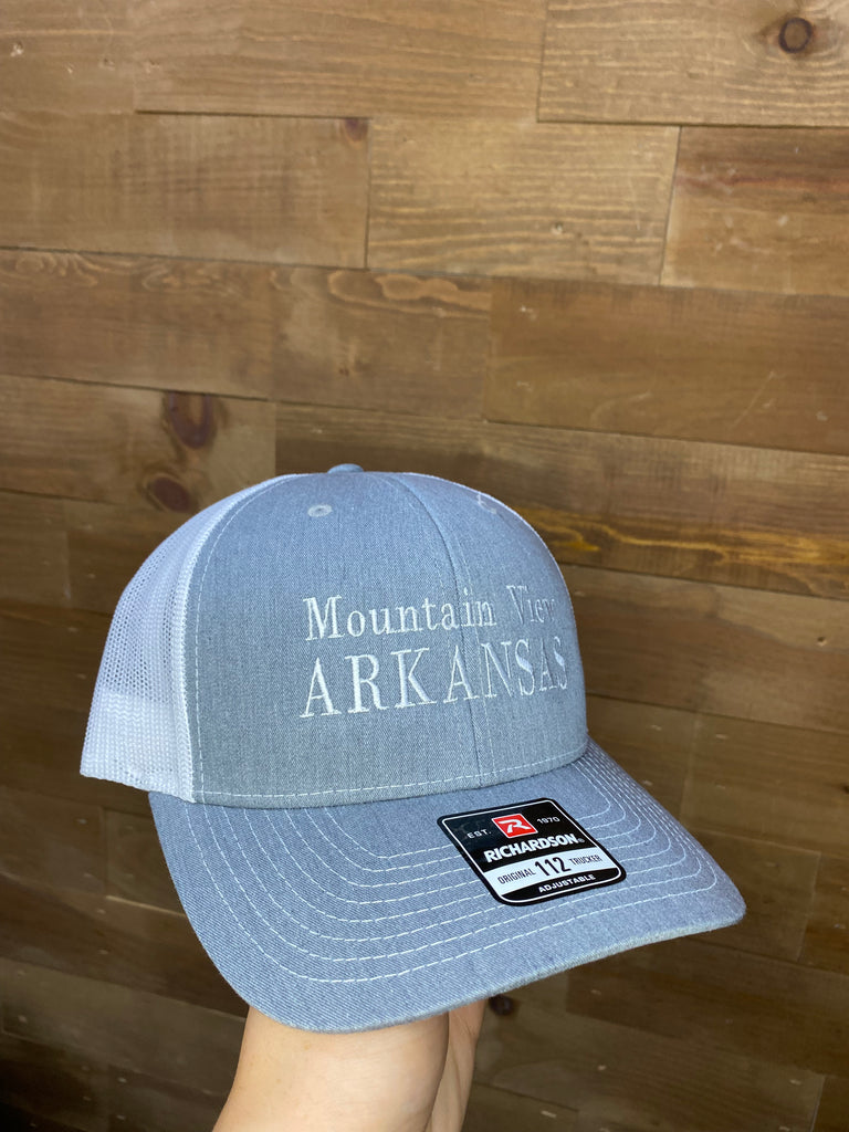 mountain view arkansas hat in front of a wood wall
