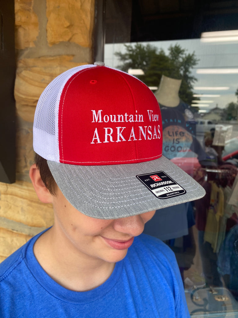 mountain view arkansas hat being worn in front of a rock building