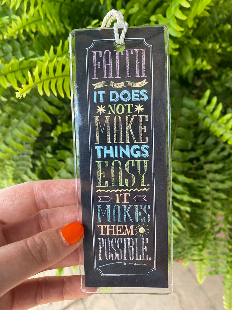 faith it does not make things easy in clear plastic cover in front on a green fern