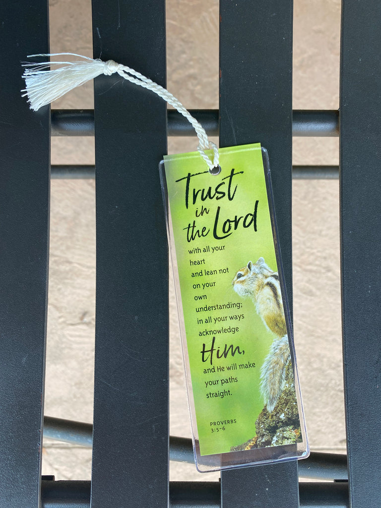 trust in the lord bookmark on a black metal bench