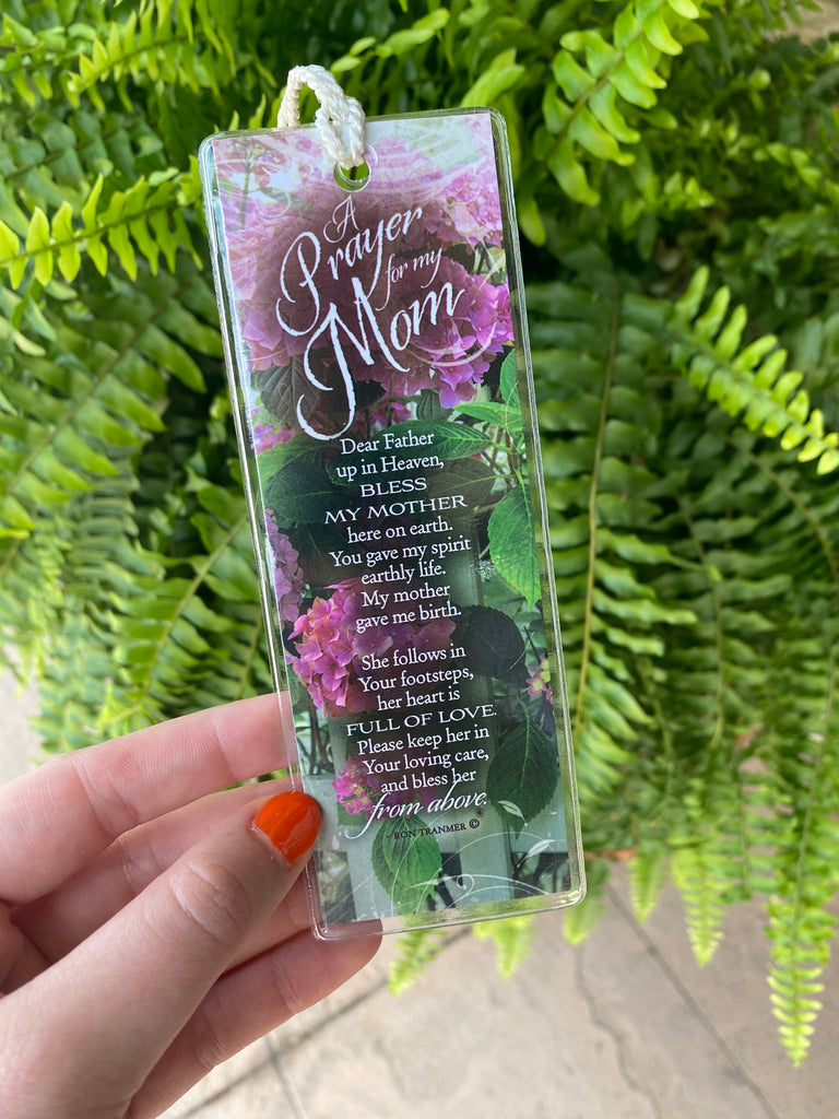 A prayer for my mom Double sided, plastic cover spiritual bookmark being held up in front of a green fern plant
