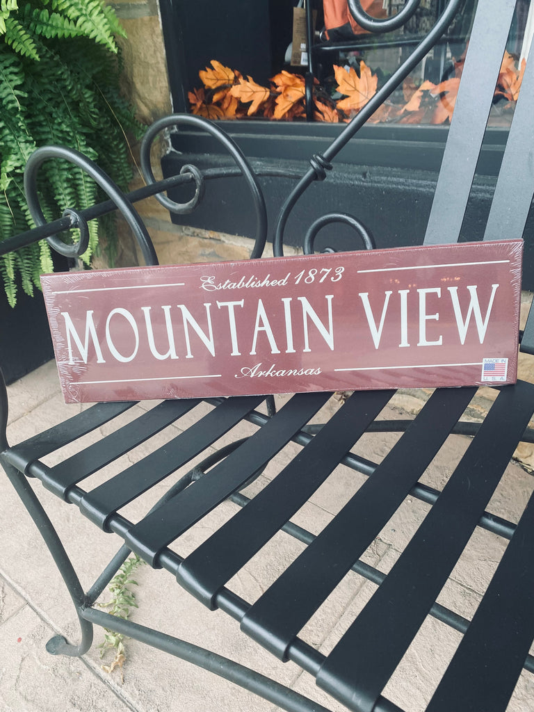 mountain view established wooden plaque on a black metal bench