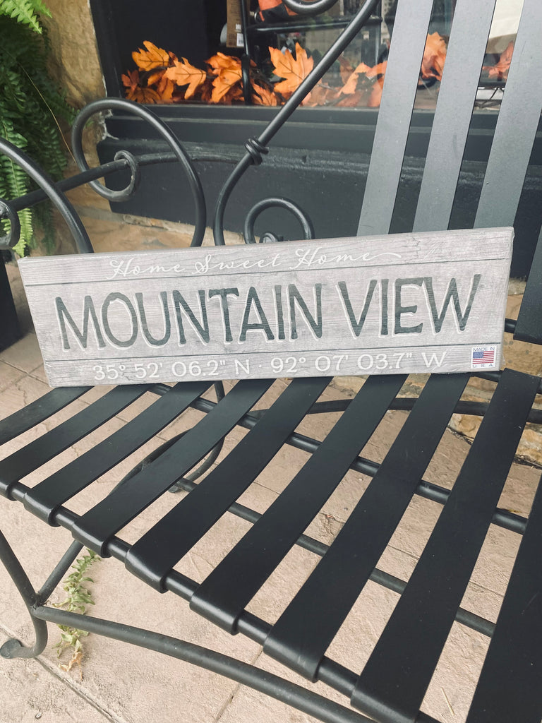 mountain view established wooden plaque on a black metal bench