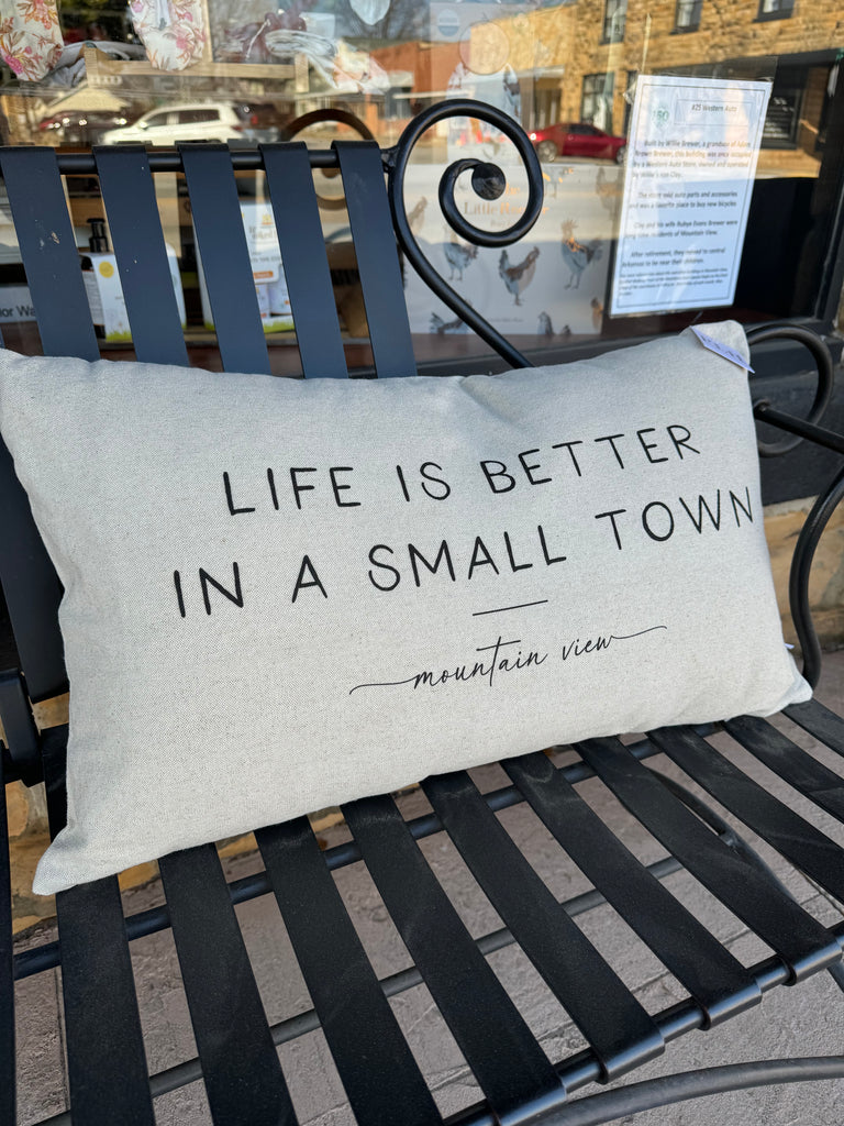 porter lane home life is better in a small town pillow on a black metal bench
