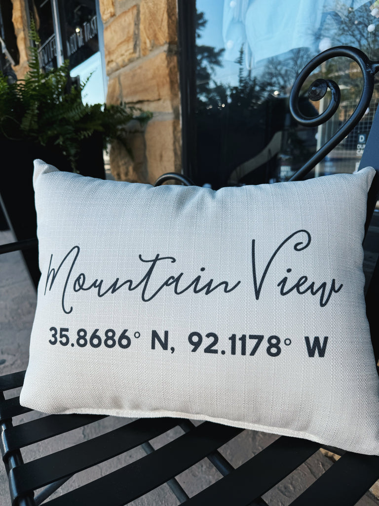 mountain view coordinates pillow on a black metal bench