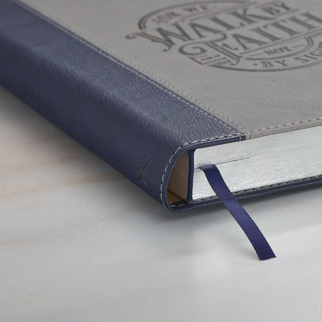 Gray notebook with a blue ribbon bookmark on a marble surface