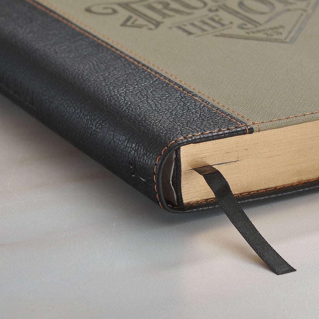 Close-up of a leather-bound book with a visible brand logo on a light background