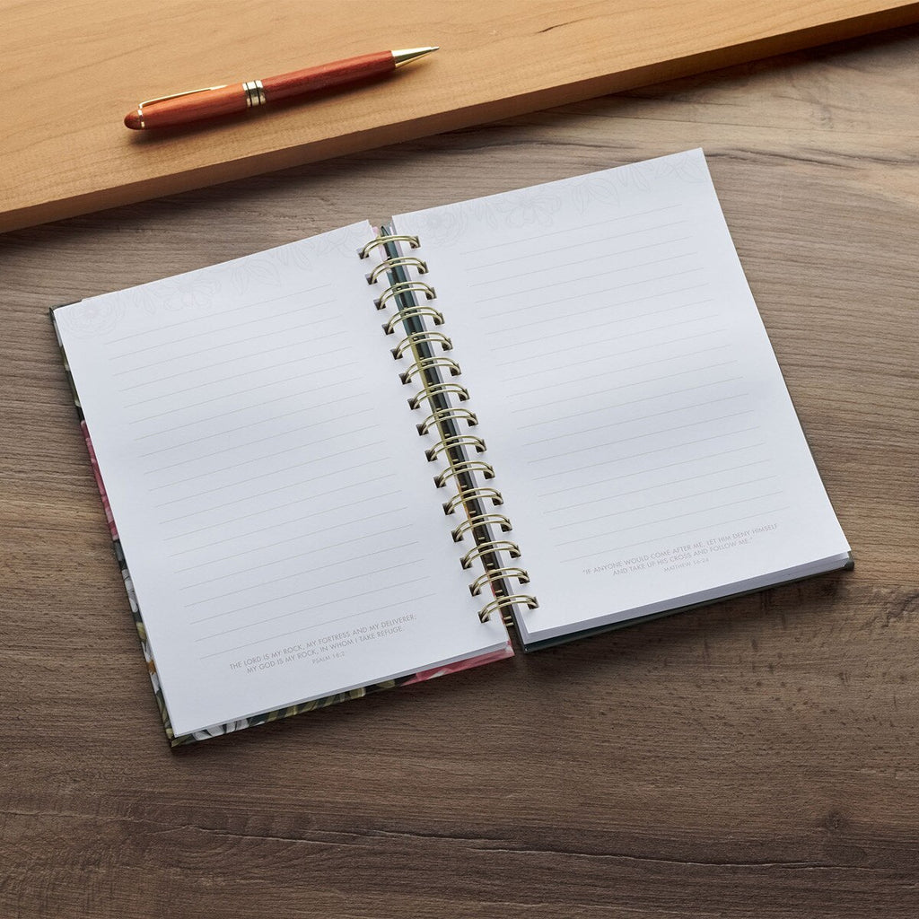 Open spiral-bound notebook on a wooden surface with a pen next to it