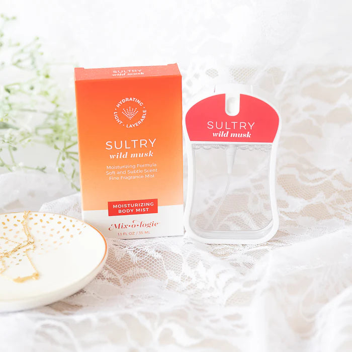 Sultry wild musk body mist packaging on a textured surface with flowers in the background