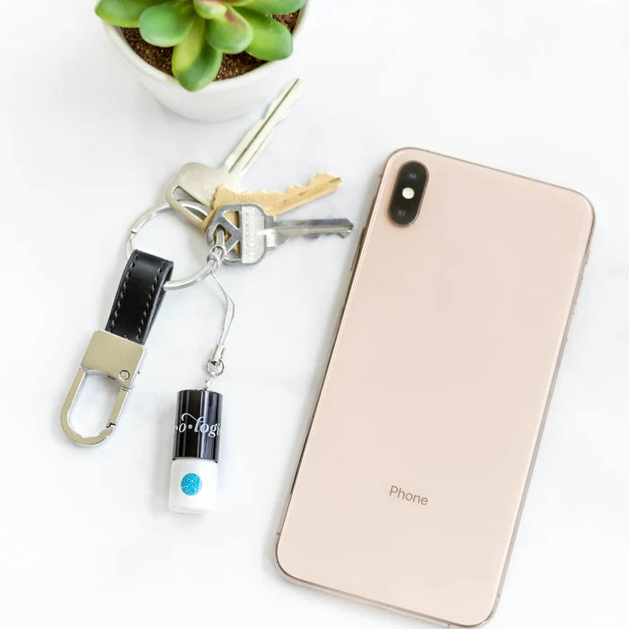Phone with keychain and keys on a white surface