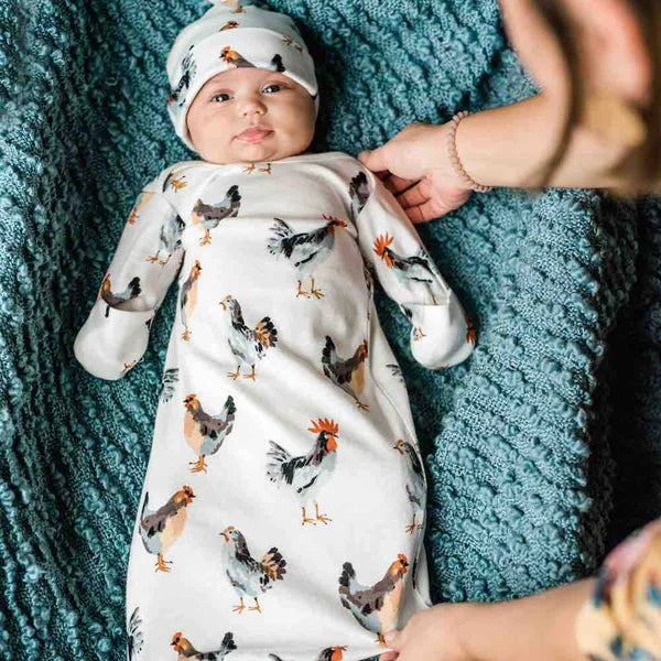 baby wearing milkbarn gown on a blue blanket