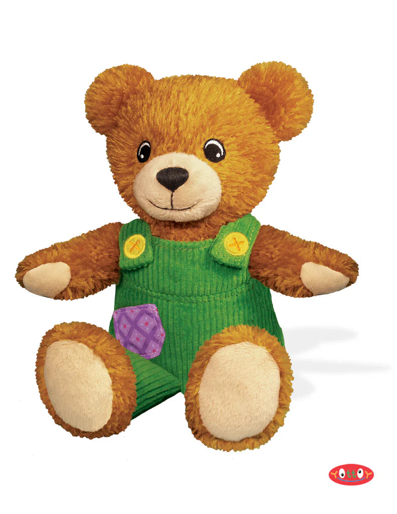 Plush teddy bear wearing green overalls on a white background