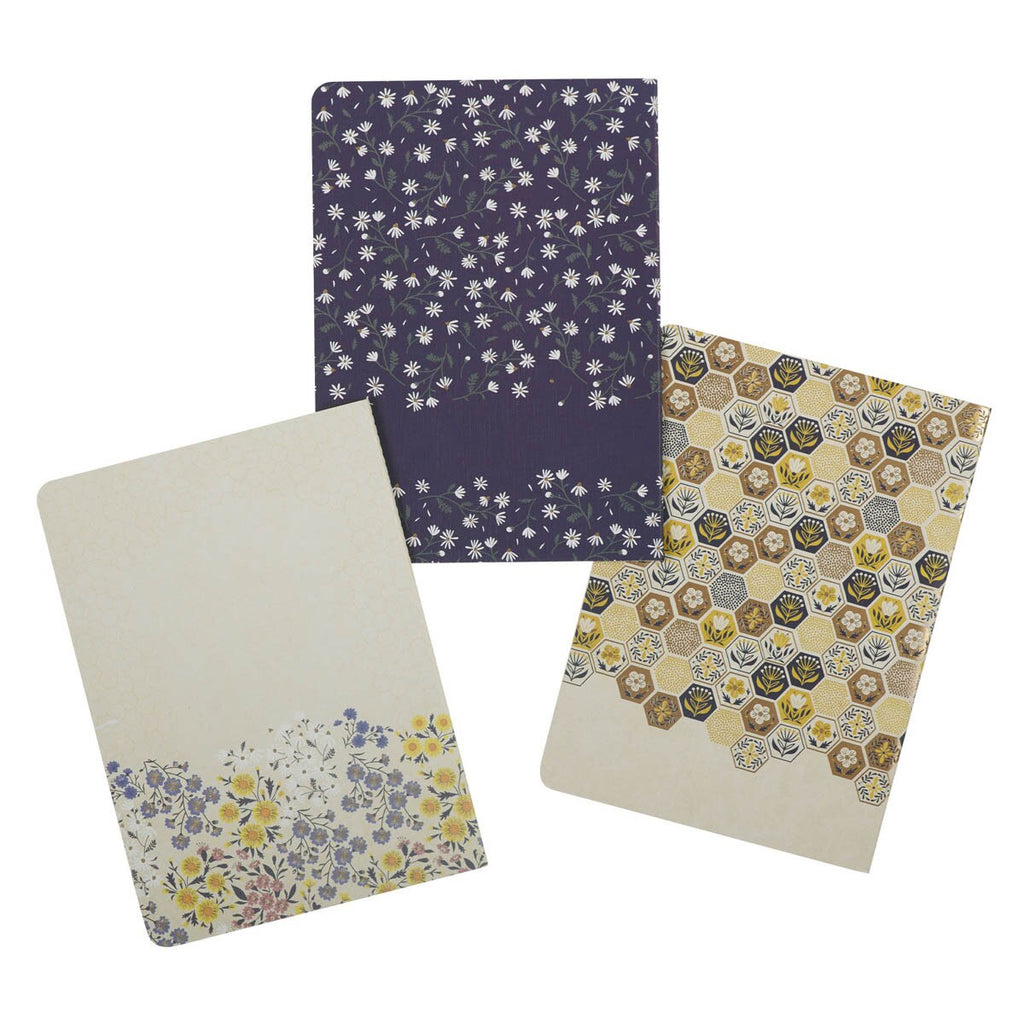 Three notebooks with floral, hexagonal patterned covers on a white background