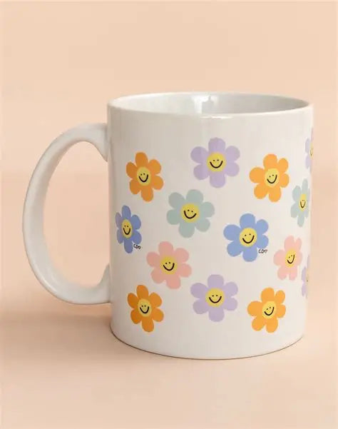 White mug with colorful flower designs on a beige background