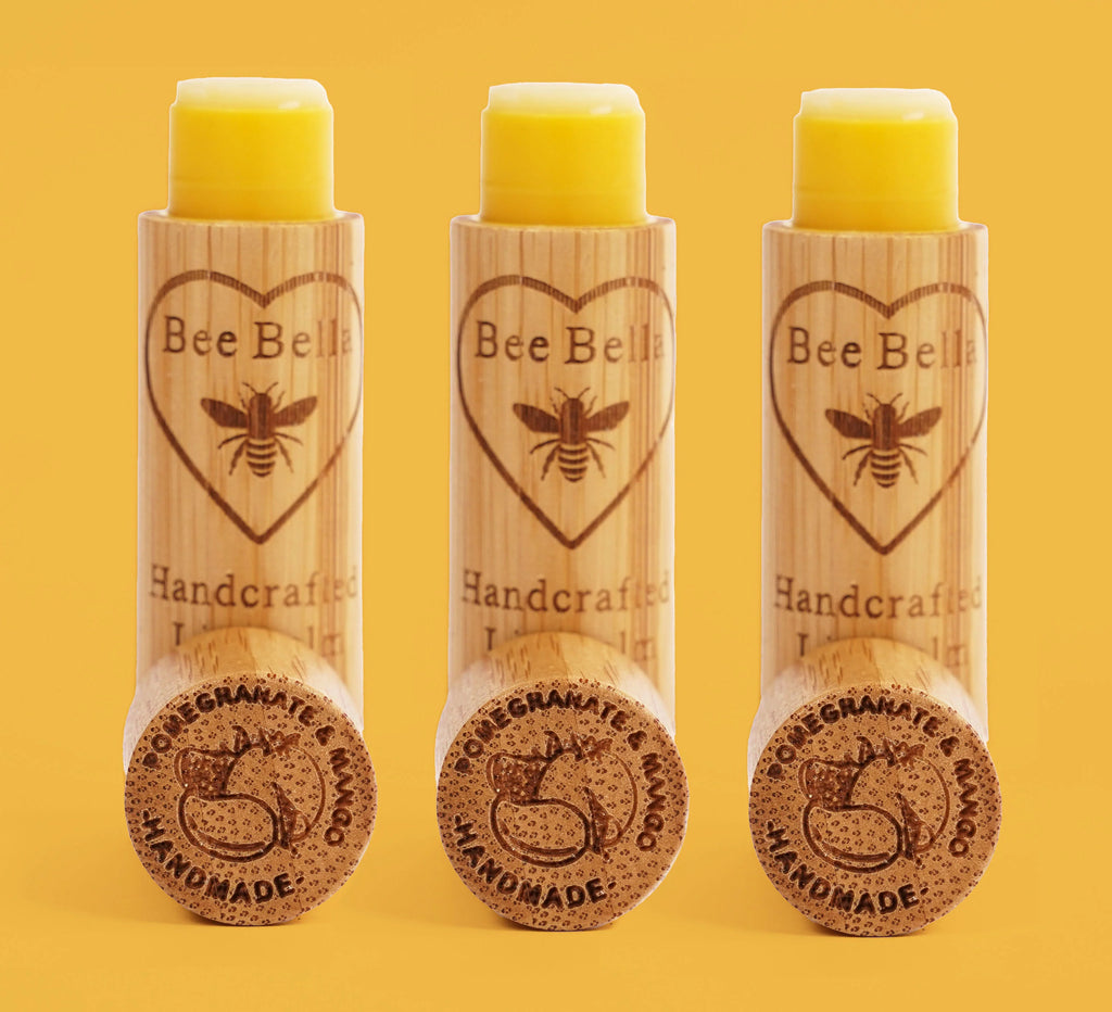 bee bella pomegranate and mango lip balm on a yellow background