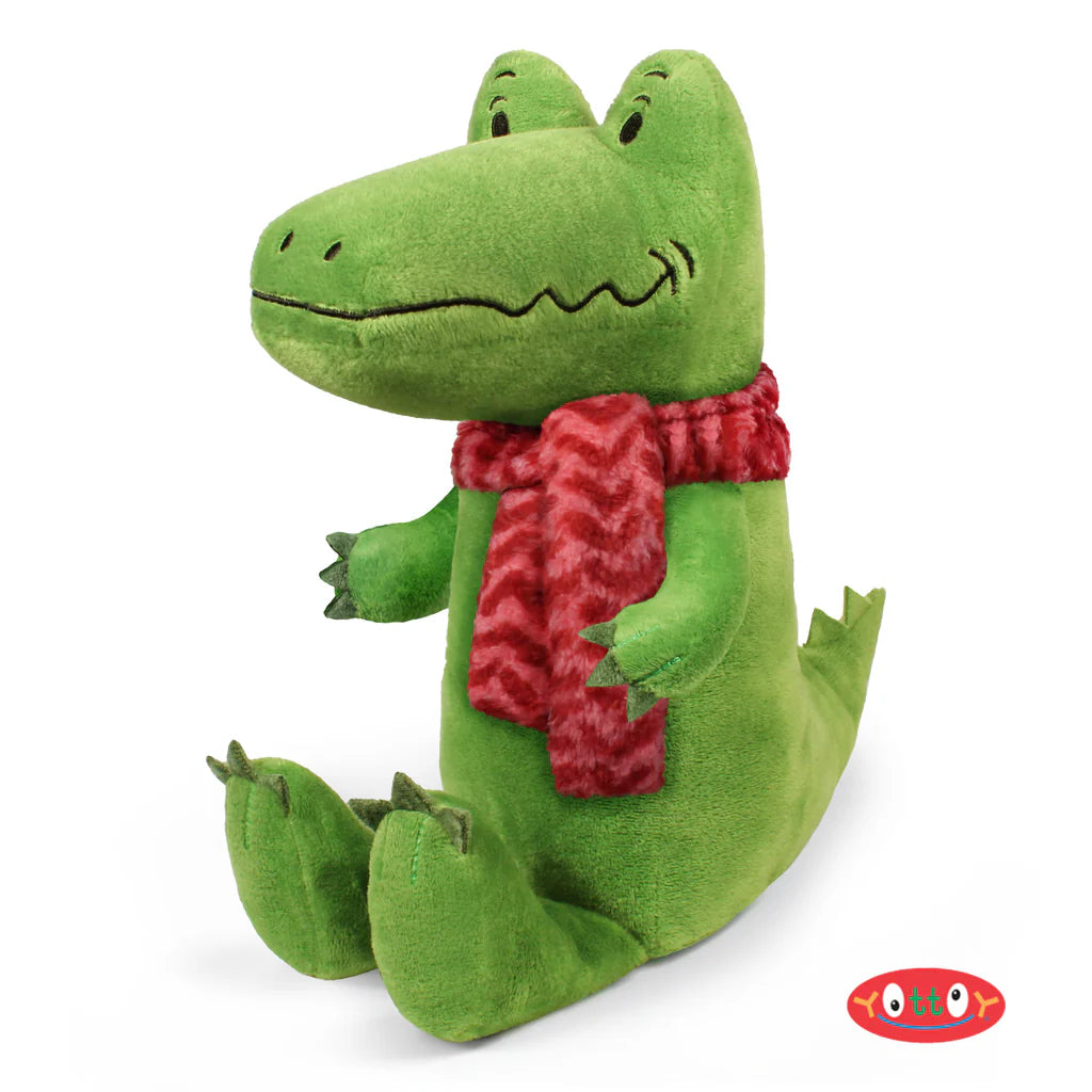 Green plush toy with a red scarf on a white background