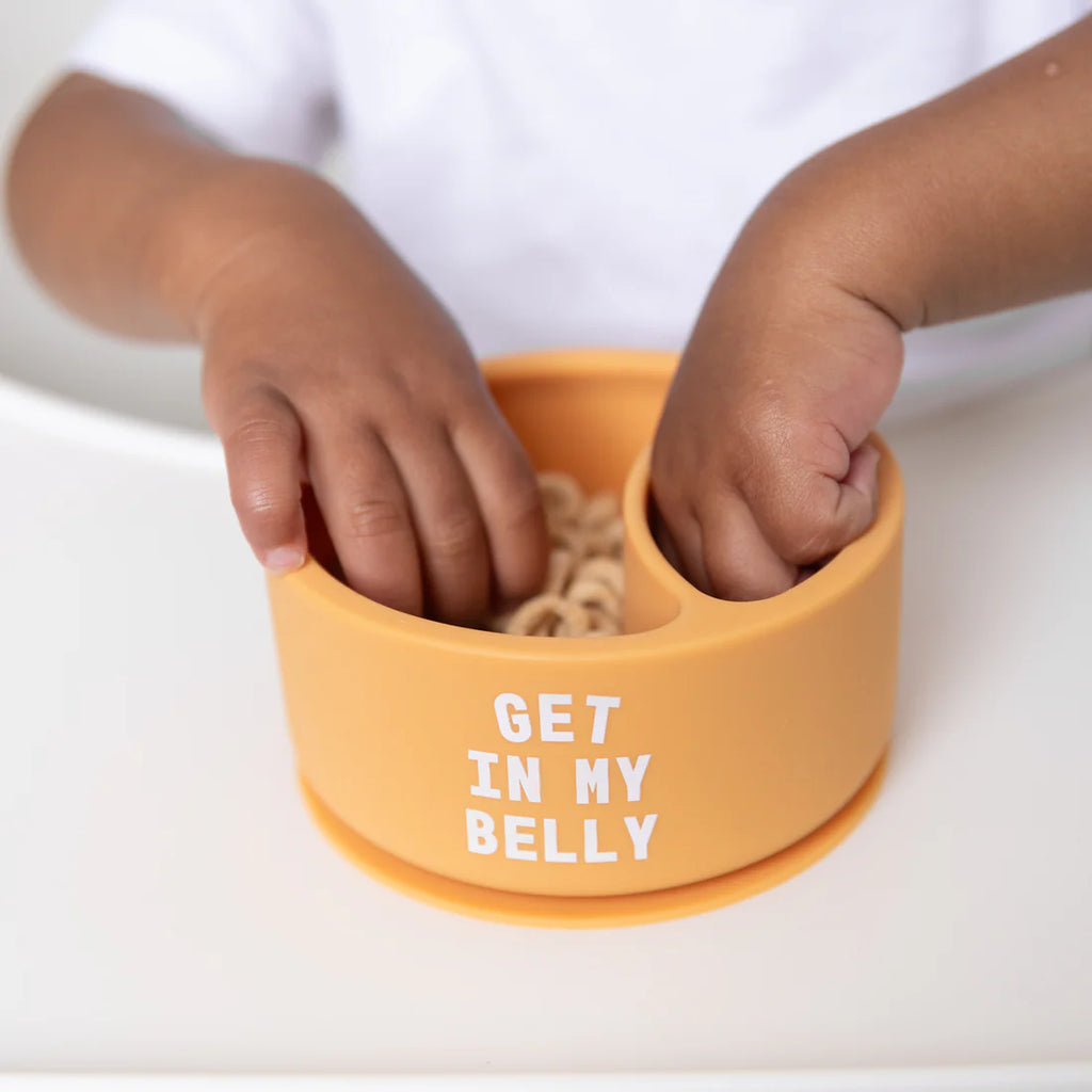 Orange bowl with 'GET IN MY BELLY' text held by a child's hands on a white background