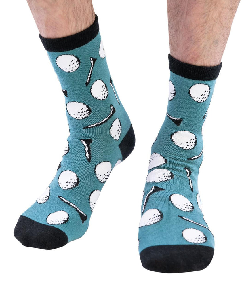 Teal socks with golf ball and club pattern worn by a person on a white background