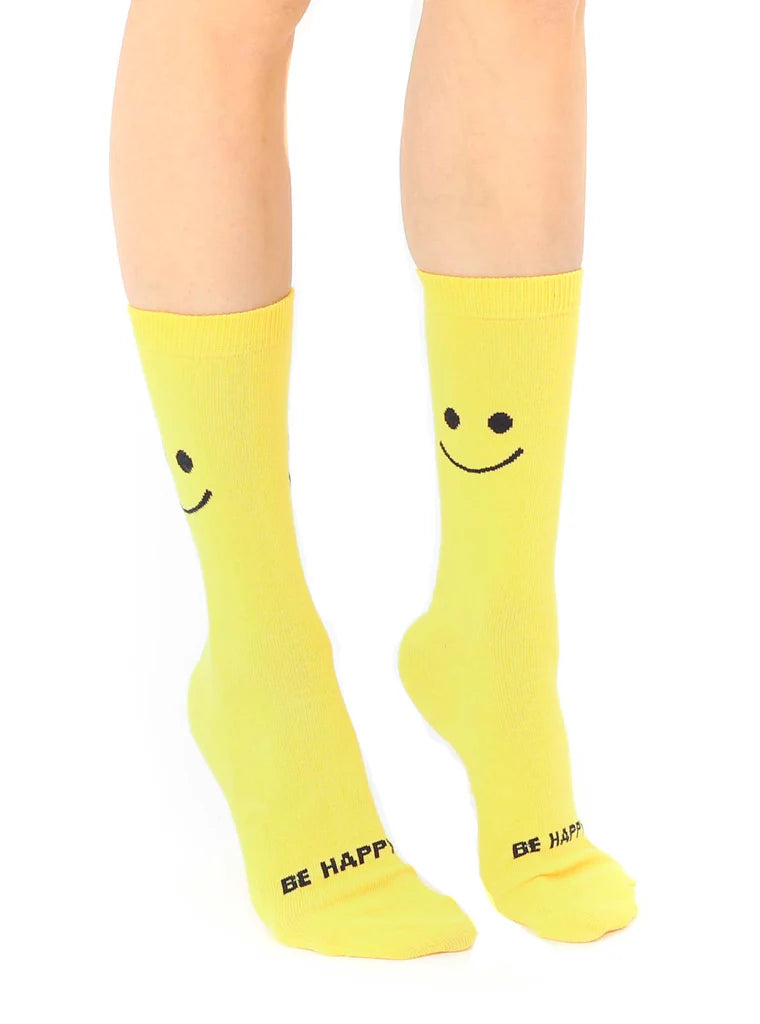 Yellow socks with smiley face design and 'Be Happy' text on a white background